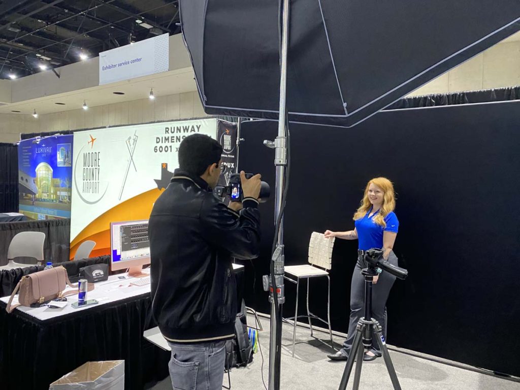 Laurent Groult takes a photo of a young woman in the fashion photo booth